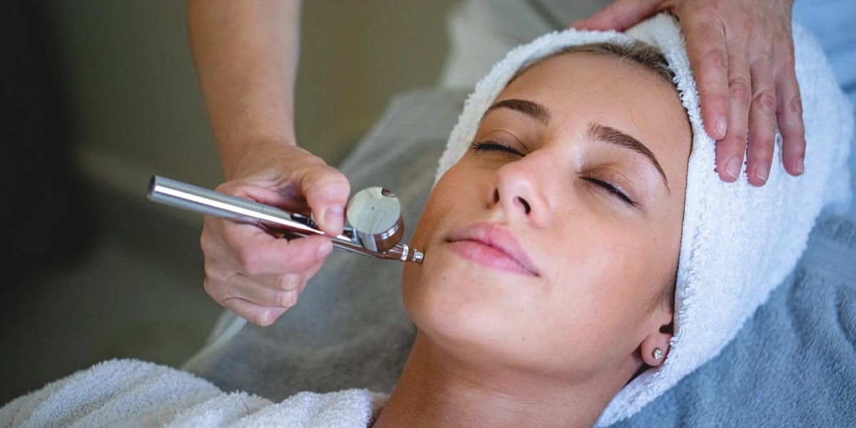 Esthetician applying facial serum to client